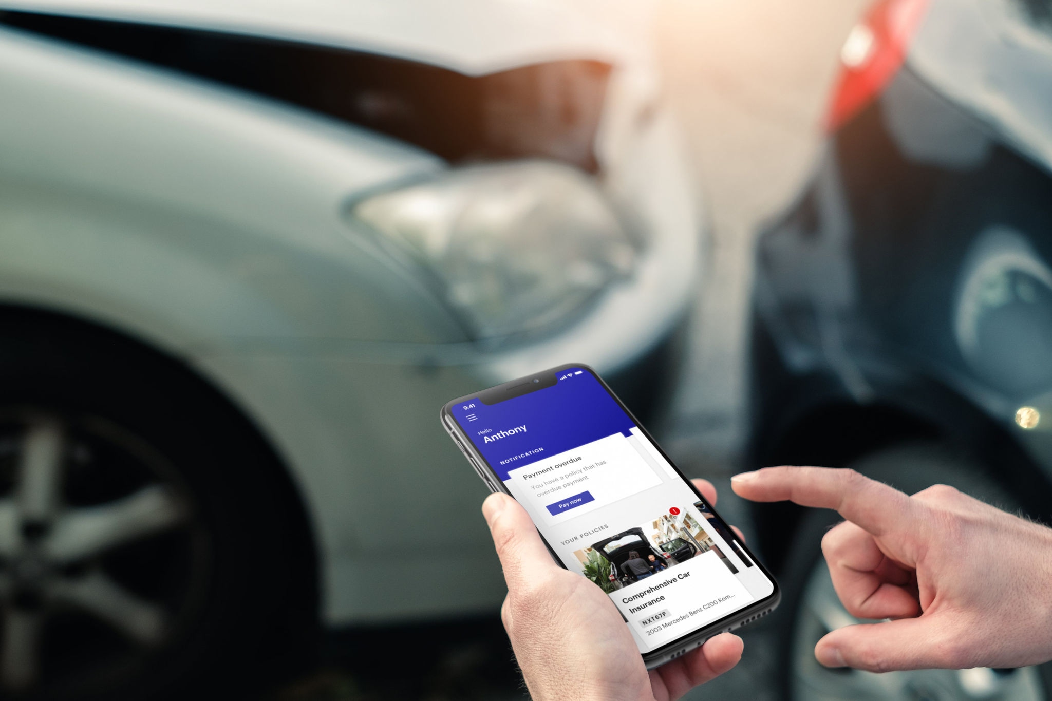 Person holding smart phone with NRMA APP in front of car crash