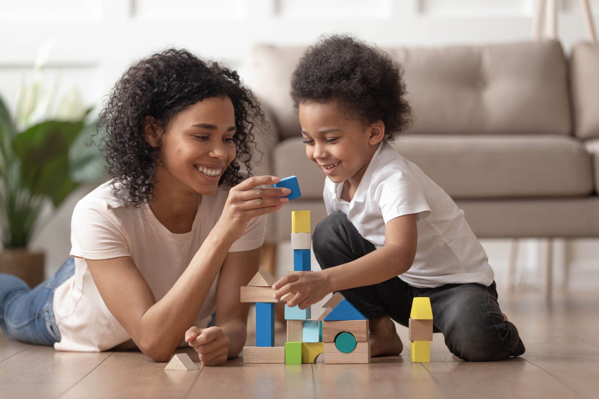 Parent and child building a tower with wooden blocks