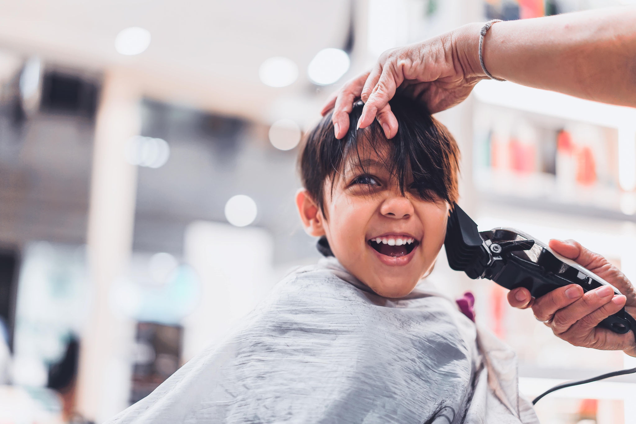 Close up of person cutting young persons hair